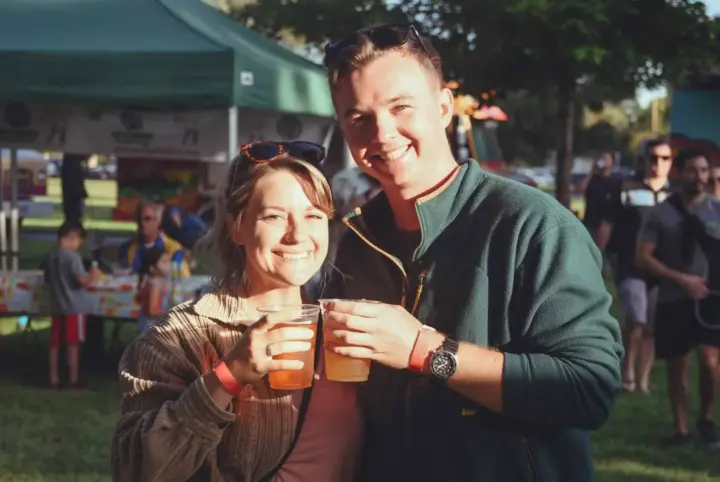 Happy couple enjoying drinks at a SactoMoFo community event in Sacramento. SactoMoFo offers mobile food services and hosts weekly events in the greater Sacramento area