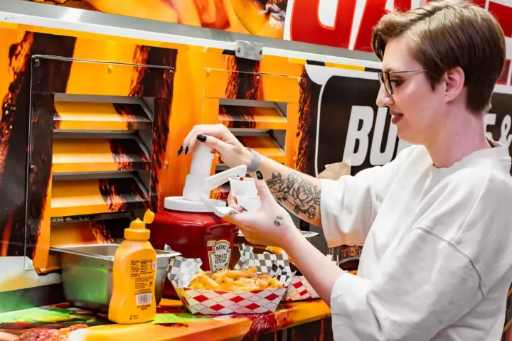 Young woman enjoying food at a SactoMoFo community event in Sacramento. SactoMoFo offers mobile food services and hosts weekly events in the greater Sacramento area